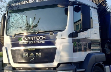 a mostly white lorry with some black above and under the windscreen. The black contains the genertech logo (which is text that says 'Genertech Power Solutions') within it.