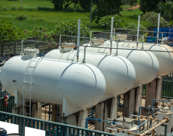 This is a stock image of 4 big grey bullet shaped petrol tanks that are on a site.