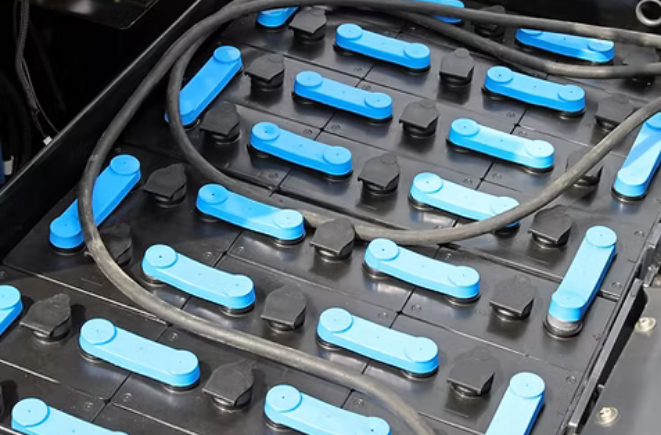 a industrial battery bank that has blue bars that connect each cell together, the rest of it is black.