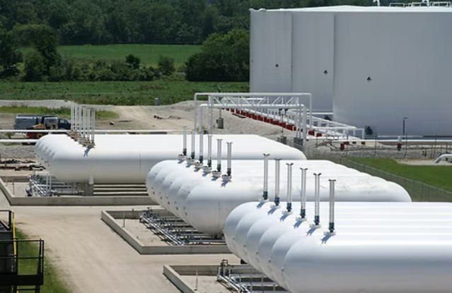 a stock image of 18 white cylindrical fuel tanks, they are in groups of six and are on a site.
